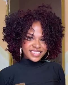 Roberta, de cachos volumosos em tom vinho.